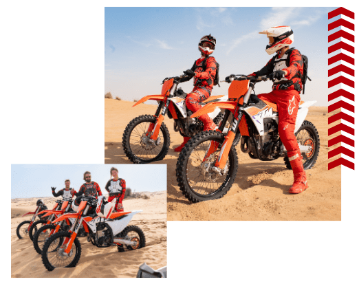 Two motorcyclists in red gear on dirt bikes in a sandy desert.