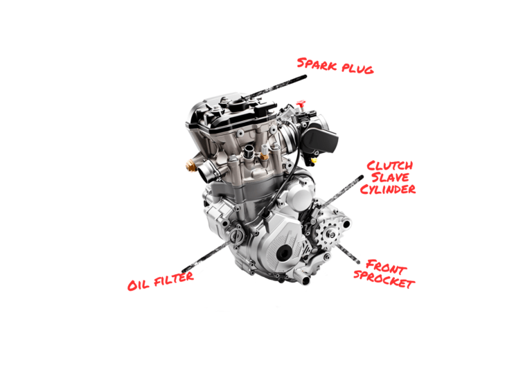 Motorcycle engine diagram with labeled parts: spark plug, clutch slave cylinder, oil filter, and front sprocket.